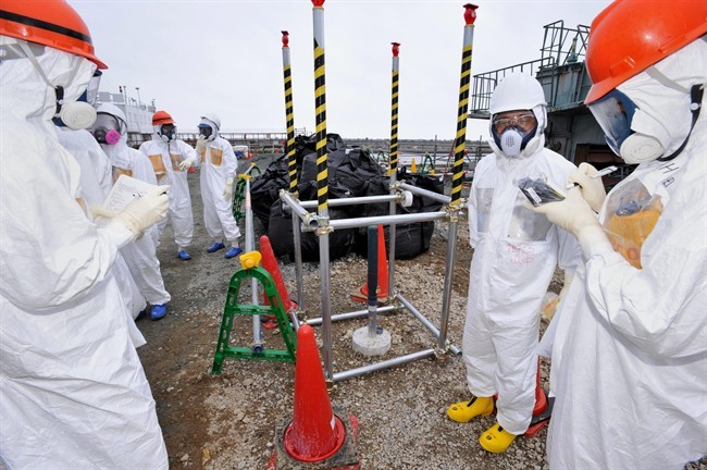 In this Aug. 6, 2013 photo, reporters inspect an observation well which is dug to take underground water samples near Fukushima Dai-ichi nuclear plant Unit 1 of Tokyo Electric Power Co., in Okuma, Fukushima prefecture, northeastern Japan. Japan’s government said Wednesday, Aug. 7, 2013, it will step in to tackle contaminated water leaks at the country’s crippled nuclear plant, and is considering funding a multibillion-dollar project to fix the problem.