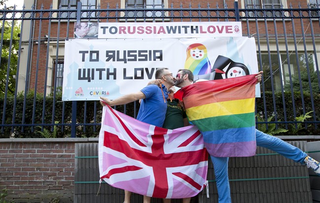 Two men take part in a kiss-in in front of the Russian Consulate in Antwerp, Belgium on Friday, Aug. 9, 2013. 