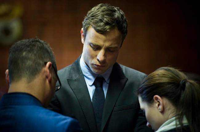 Oscar Pistorius cries as he prays with his sister Aimee and brother Carl in the magistrates court in Pretoria, South Africa, Monday, Aug. 19, 2013. 