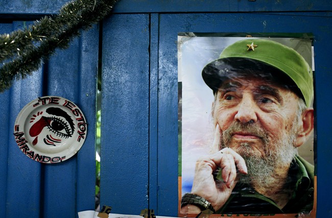 A poster of Cuba's Fidel Castro hangs on the wall of a food market in Havana next to a plate that reads in Spanish, "I'm looking at you," Tuesday, Aug. 13, 2013.