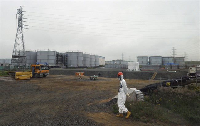 In this Wednesday, June 12, 2013 file photo, a construction worker walks beside the underground water tanks at the Fukushima Dai-ichi nuclear plant at Okuma in Fukushima prefecture, Japan where about 300 tons of highly radioactive water has leaked.