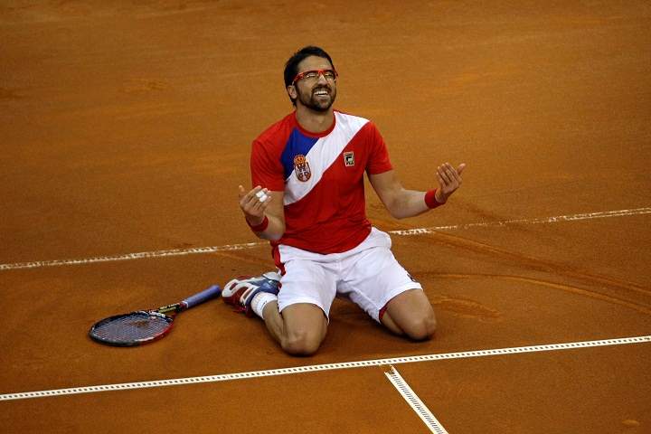 Serbia's Janko Tipsarevic falls to his knees as he celebrates his team's victory at the Davis Cup semifinal against Canada in Belgrade, Serbia, Sunday, Sept. 15, 2013.