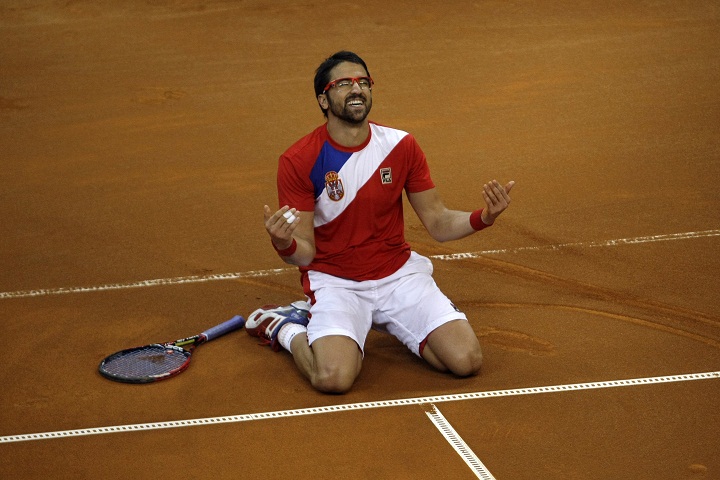 Serbia's Janko Tipsarevic falls to his knees as he celebrates his team's victory at the Davis Cup semifinal against Canada in Belgrade, Serbia, Sunday, Sept. 15, 2013.