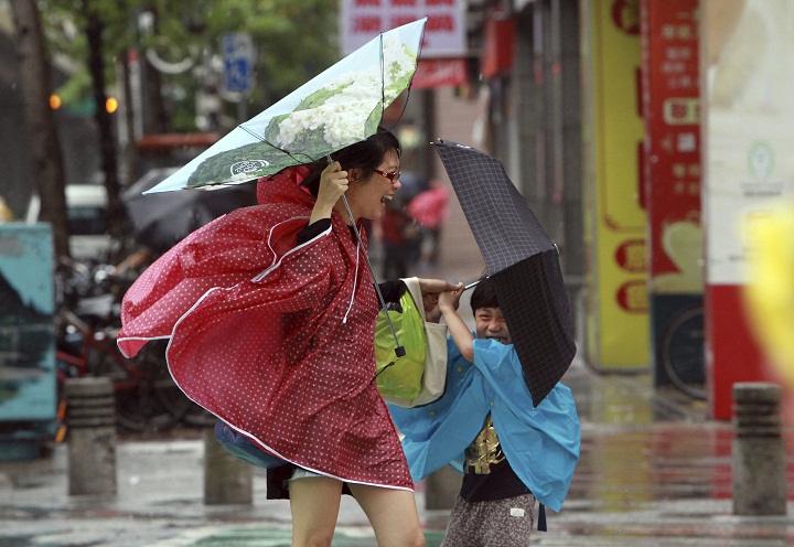 A woman and her child hold their umbrellas tight against powerful gusts of wind as typhoon Usagi approaches in Taipei, Taiwan, Saturday, Sept. 21, 2013. The most powerful typhoon of the year swept through the Luzon Strait separating the Philippines and Taiwan on Saturday, battering island communities and dumping rain as it eyes landfall in Hong Kong. Taiwan's Central Weather Bureau said later Saturday that Usagi was veering west, likely sparing southern Taiwan from the most destructive winds near its eye. 