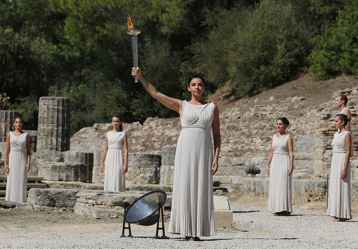 Actress Ino Menegaki as high priestess, holds a torch after the Olympic Flame was lit from the sun’s rays, during the final dress rehearsal for the lighting of the Olympic flame at Ancient Olympia, in west southern Greece on Saturday, Sept. 28, 2013. The flame will be transported by torch relay to the Russian resort of Sochi, which will host the Feb. 7-23, 2014 Winter Olympics.
