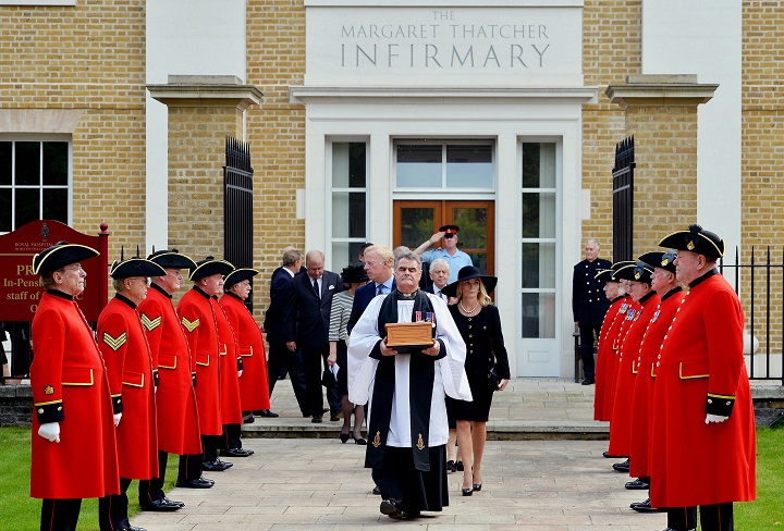 Reverend Richard Whittington, foreground centre, carries an oak casket containing the ashes of former British Prime Minister Margaret Thatcher, followed by her daughter Carol, son Mark, centre left and his wife Sarah, centre left, after leaving the chapel, at the Royal Hospital Chelsea, London, Saturday Sept. 28, 2013. The country's first female prime minister died aged 87 on April 8, following a stroke. Her ashes will be laid to rest in the grounds of the hospital.
