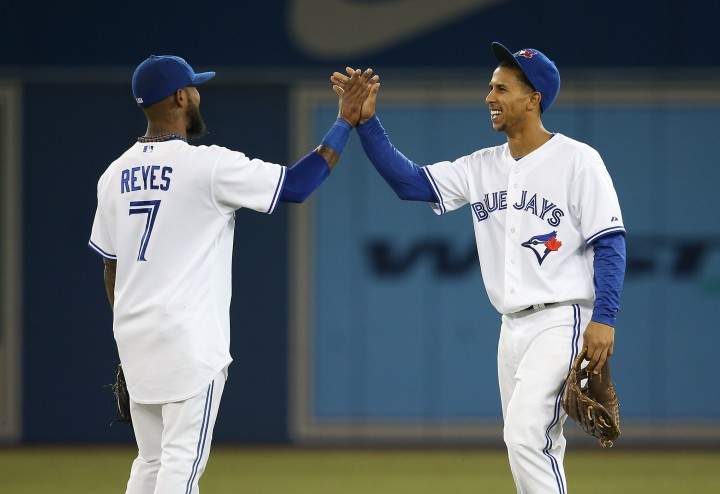 Anthony Gose #8 of the Toronto Blue Jays celebrates their victory with Jose Reyes #7 during MLB game action against the Tampa Bay Rays on September 27, 2013 at Rogers Centre in Toronto, Ontario, Canada. 