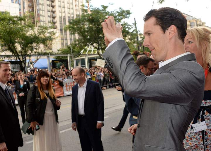 While Paul Giamatti quietly mocked him, Benedict Cumberbatch used his imaginary camera to take a picture of the crowd outside the Princess of Wales Theatre. (Getty Images)