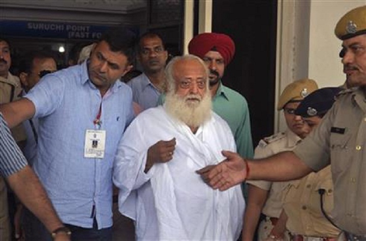 Controversial spiritual guru Asaram Bapu, center, is brought for interrogation by police at Jodhpur airport in Jodhpur, India, Sunday, Sept. 1, 2013. Bapu was arrested early Sunday on a rape charge filed by a teen-age girl in the northwestern Indian state of Rajasthan, police said. The case is the latest in a series of high-profile rape cases in India that have fueled public protests and raised questions about how police handle the cases and treat the victims. 