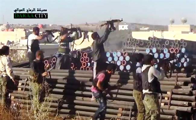 In this image taken from Wednesday, Sept. 25, 2013, video obtained from the Sham News Network, Syrian opposition fighters fire at government forces near Daraa customs in Daraa al-Balad, Syria. 