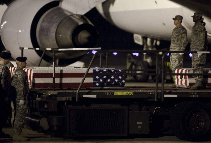 A U.S. Army and Air Force carry team stands with transfer cases carrying the remains of Maj. Matthew P. Houseal, of Amarillo, Texas; Sgt. Christian E. Bueno-Galdos, of Paterson, New Jersey; and Pvt. 1st Class Michael E. Yates, of Federalsburg, Maryland, at Dover Air Force Base May 13, 2009 in Dover, Delaware. The remains of Houseal, Bueno-Galdos and Yates were returned to the U.S. States after they, and three others, were killed by Sgt. John Russell, of Sherman, Texas, during a shooting at Camp Liberty in Iraq, according to Army officials. (Photo by Brendan Smialowski/Getty Images).