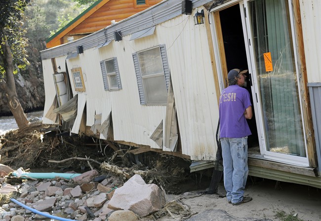 Dirk Huntington checks on a friend's flood-damaged trailer at the River Bend Mobile Home Park in Lyons, Colo., on Thursday, Sept. 19, 2013. Hundreds of evacuees were allowed past National Guard roadblocks Thursday to find a scene of tangled power lines, downed utility poles, and mud-caked homes and vehicles. 