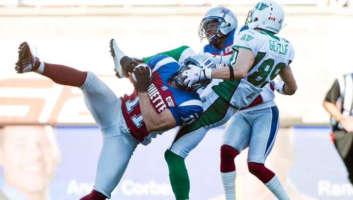 Montreal Alouettes' Chip Cox, left, intercepts a pass intended for Saskatchewan Roughriders' Chris Getzlaf, right, as Alouettes' Geoff Tisdale, centre, closes in during second half CFL football action in Montreal, Sunday, September 29, 2013.