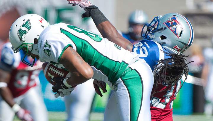 Saskatchewan Roughriders' Geroy Simon (81) makes a catch to break Ben Cahoon's all-time CFL catch record as Montreal Alouettes' Jerald Brown defends during first half CFL football action in Montreal, Sunday, September 29, 2013.