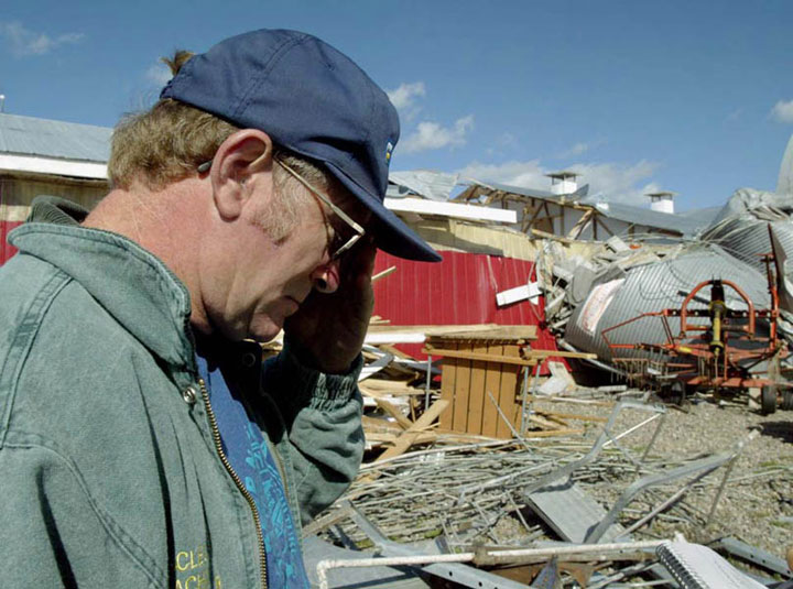 Havey Whidden pauses as he views the damage to milking parlour on his farm in near Stewiacke, N.S. on Friday, Oct. 3, 2003 following Hurricane Juan.