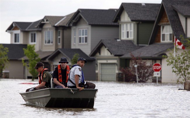 Members of the RCMP return from a boat patrol of a flooded neighborhood in High River, Alta., July 2013.