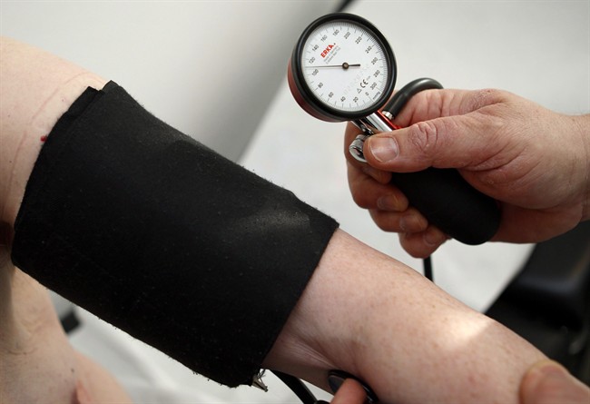 A doctor takes the blood pressure of a man.