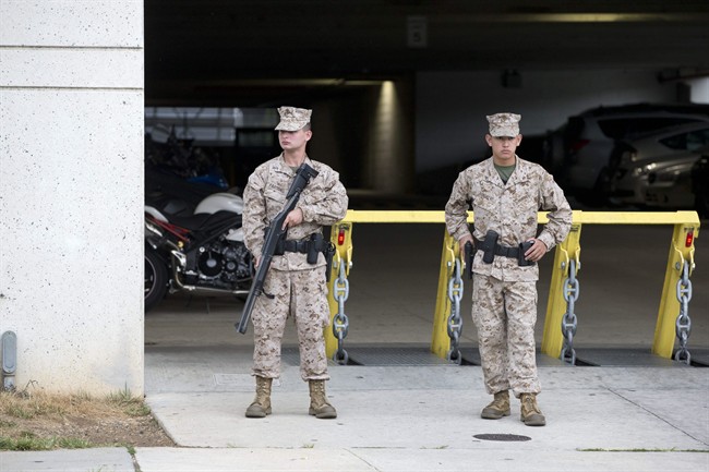Members of the military guard a military garage near the Washington Navy Yard where a gunman was reported in Washington, on Monday, Sept. 16, 2013. (AP Photo/Jacquelyn Martin)