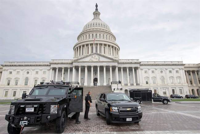 U.S. Capitol Police personnel keep watch on the East Plaza of the Capitol as the investigation continues to the shooting at the nearby Washington Navy Yard Monday, Sept. 16, 2013, in Washington. At least one gunman opened fire inside a building at the Washington Navy Yard on Monday morning, and officials said six people were killed and as many as 10 were wounded, including a law enforcement officer. (AP Photo/J. Scott Applewhite).