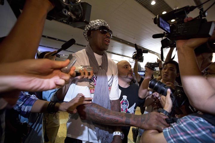 Retired NBA star Dennis Rodman, center, attempts to get through journalists upon arriving at the Beijing capital airport in Beijing, China, Saturday, Sept. 7, 2013. Rodman left North Korea Saturday, professing his affection for autocratic leader Kim Jong Un and angrily rejecting calls for him to lobby for the release of imprisoned American citizen Kenneth Bae. 