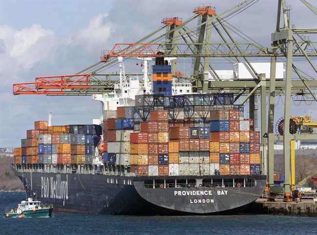 A work boat heads past a container ship at the Ceres terminal in Halifax in a file photo.