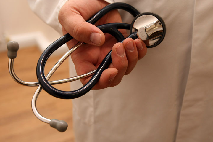 A doctor holds a stethoscope.