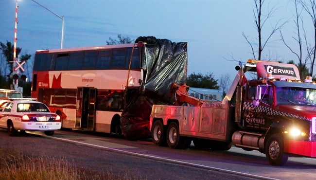 The bus in which six people died is towed away from the site of the fatal bus and train crash in Ottawa, Thursday, September 19, 2013.