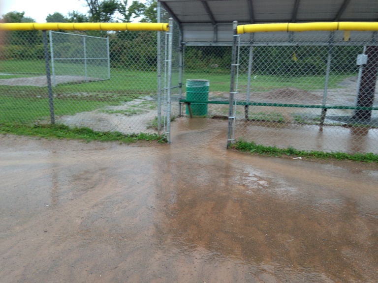 Rain fills up the dugout at a Bedford baseball diamond.