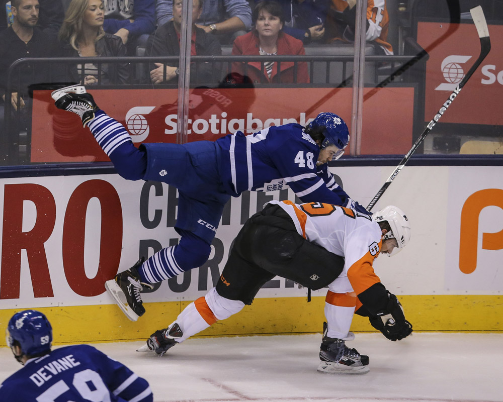 Toronto Maple Leafs left wing Bradley Ross (48) get hit into the boards by Philadelphia Flyers center Rob Bordson (65) during the second period of the game between the Toronto Maple Leafs and the Philadelphia Flyers September 16, 2013.