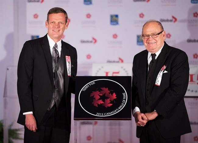 FILE PHOTO: Terry Fox's brother, Darrell, left, and father Rolly, right, pose for a photo during the cancer activist's induction ceremony into Canada's Walk of Fame in Toronto on Saturday, September 21, 2013.
