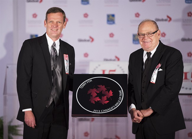 FILE PHOTO: Terry Fox's brother, Darrell, left, and father Rolly, right, pose for a photo during the cancer activist's induction ceremony into Canada's Walk of Fame in Toronto on Saturday, September 21, 2013.