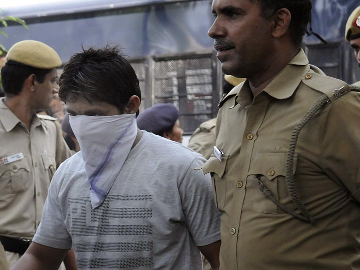 Indian police officials escort Pawan Gupta, one of the men convicted in the Delhi gang-rape case, to an appearance at the High Court in New Delhi on September 24, 2013.  