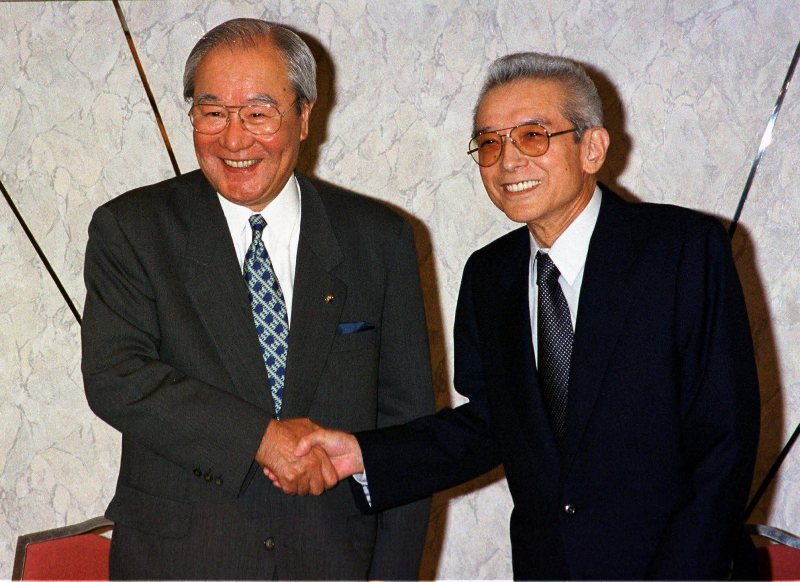 Yoichi Morishita, president of Matsushita Electric Industrial Co., left, and Hiroshi Yamauchi, president of Nintendo Co., shake hands during a news conference in Tokyo Wednesday, May 12, 1999. 