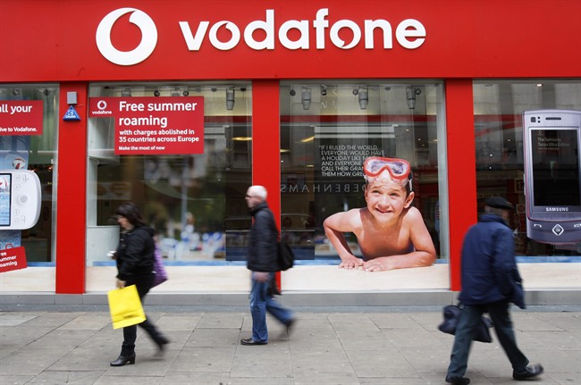 In this Tuesday, May 19, 2009, file photo, people walk by a branch of Vodafone in central London. Verizon says, Monday, Sept. 2, 2013, it has agreed to buy Vodafone's stake in Verizon Wireless for $130 billion. (AP Photo/Sang Tan, File).