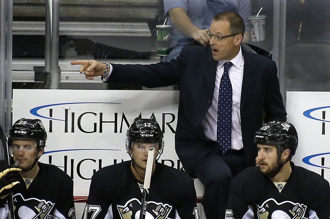 In this photo taken on Sept. 23, 2013, Pittsburgh Penguins head coach Dan Bylsma works from the bench during an NHL preseason hockey game against the Chicago Blackhawks in Pittsburgh.