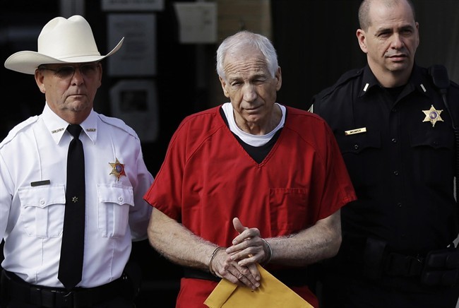 FILE - In this Oct. 9, 2012 file photo, former Penn State University assistant football coach Jerry Sandusky, centre, is taken from the Centre County Courthouse by Centre County Sheriff Denny Nau, left, and a deputy, after being sentenced in Bellefonte, Pa. 