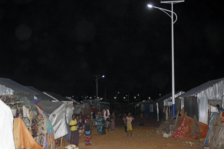 In this photo taken Thursday, July,11, 2013, children play under the solar powered street lights at a refugee camp in Mogadishu, Somalia. 