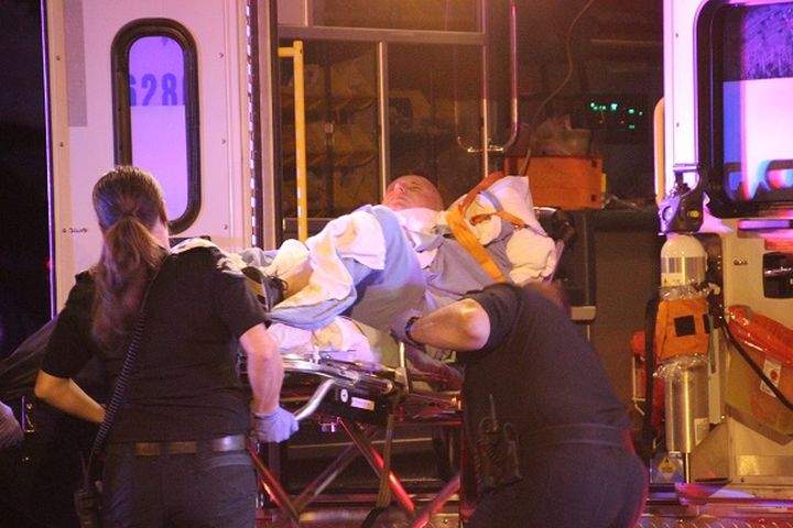 A man is loaded into an ambulance after being shot in the abdomen, according to Surrey RCMP. 