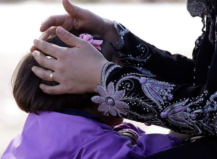 A Syrian refugee caresses a child as she gathers with her family in the village of Salkin after crossing the Syrian-Turkish border, Thursday, Sept. 5, 2013. (Photo credit: (AP Photo)New York National Guard Staff Sgt. Edwin Caba, left, is reunited with one of eight dogs rescued from the battlefield in Afghanistan and flown to New York, Wednesday, Sept. 4, 2013 in Port Jefferson Station, NY, where they are to be adopted by some of the soldiers who found them in Afghanistan. (Photo credit: AP Photo)