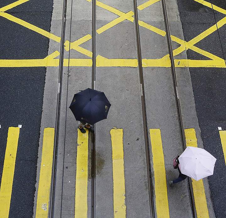 A few pedestrians walk along a quiet Des Voeux Road in Hong Kong’s CBD on September 23, 2013.   (Photo credit: Getty Images)