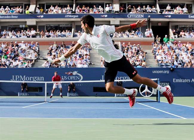 Novak Djokovic, of Serbia, goes airborne to return a shot to Stanislas Wawrinka, of Switzerland, during the semifinals of the 2013 U.S. Open tennis tournament, Saturday, Sept. 7, 2013, in New York. (AP Photo/Charles Krupa).