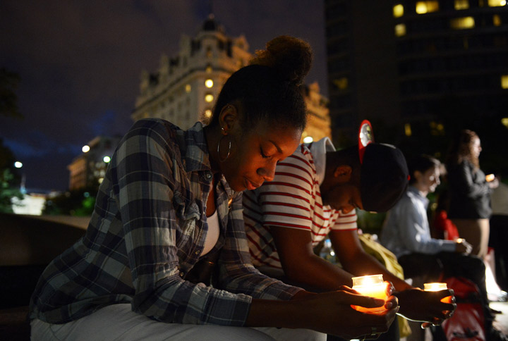 Brittany Carter, center, and Jibri Johnson, right center, take part in a candle light vigil at Freedom Plaza for the mass shooting at the U.S. Navy Yard on Monday September 16, 2013 in Washington, DC. 
