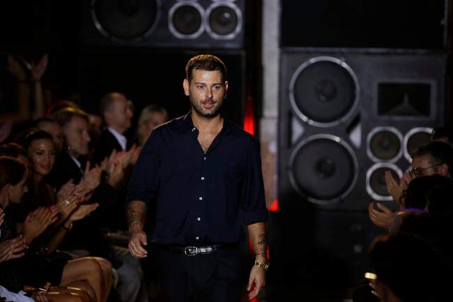 Italian fashion designer Fausto Puglisi acknowledges the applause of the audience after presenting his women's Spring-Summer 2014 collection, part of the Milan Fashion Week, unveiled in Milan, Italy, Sunday, Sept. 22, 2013. 