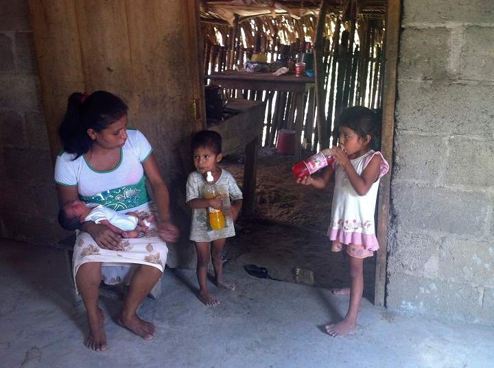 In this Oct. 6, 2013 photo, 29-year-old Irma Lopez talks to her children as her newborn son Salvador sleeps on her lap at her home in the town of Jalapa de Diaz, Mexico. A photo of Lopez grimacing in pain during the first moments after giving birth, with her child still bound to her by the umbilical cord, on the lawn of a clinic has gone viral and served as a reminder of the health disparities still affecting many poor women in Mexico without proper access to health care. A nurse kicked Lopez out of the clinic Oct. 2, claiming she was “still not ready” and had to wait for a doctor. (AP Photo/Chema Alvarez)