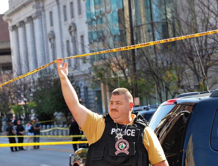 An Ohio County Sherriff Department deputy secures an area in front of the Federal Buildng in Wheeling, West Virginia Wedneday, Oct. 9, 2013, following a shooting outside the courthouse. West Virginia State Police say a man who fired shots at a federal courthouse in Wheeling has died from police fire. State police spokesman Sgt. Michael Baylous confirmed that the man died Wednesday. The U.S. Marshals Services says officers fired at the man after he shot up to two dozen rounds at the courthouse. 