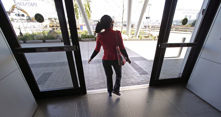 In this Friday, Sept. 27, 2013 photo, Mery Daniel, a Boston Marathon bombing survivor, walks out the front door of Spaulding Rehabilitation Hospital following a physical therapy session in Boston. Daniel, whose heart stopped twice while she was being treated for trauma from the April 15 bombings, lost much of her left leg. Nearly six months later, she has slowly begun to regain parts of her mobility and her independence. (AP Photo/Charles Krupa)