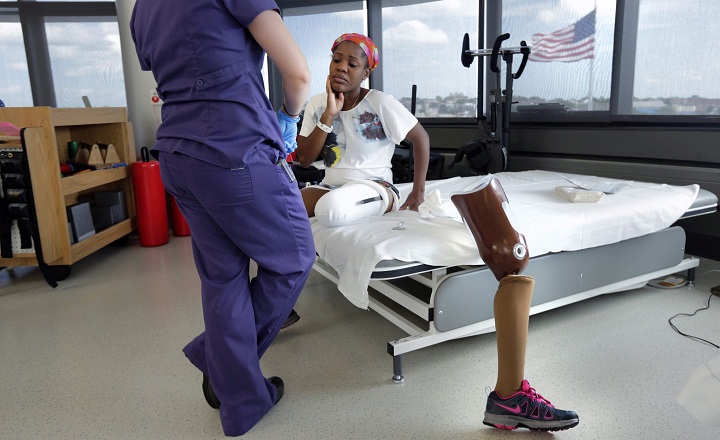 In this Wednesday, July 3, 2013 photo, Mery Daniel, a Boston Marathon bombing survivor, pauses while she talks with her physical therapist Jessica Guilbert, while she takes a break from exercising with her prosthetic leg at Spaulding Rehabilitation Hospital in Boston. Daniel, a 31-year-old medical school graduate, lost most of her left leg in the blast that killed three people and injured more than 260 others. (AP Photo/Charles Krupa)