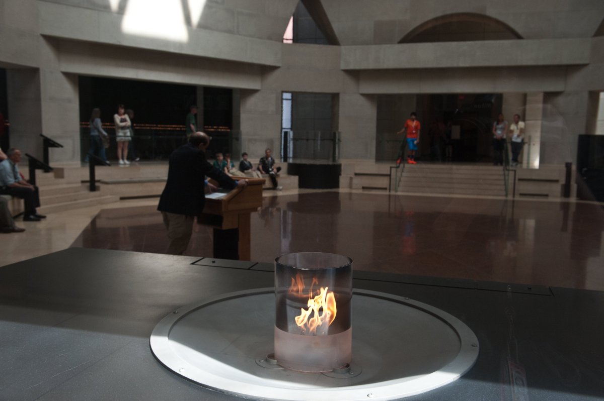 The flame burns as a man reads the names of victims of the Holocaust in the Hall of Remebrance at the Holocaust Memorial Museum in Washington on April 8, 2013.