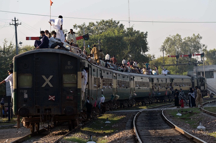 FILE: Pakistanis ride an overcrowded train to return home for Eid al-Adha in Lahore on October 14, 2013.