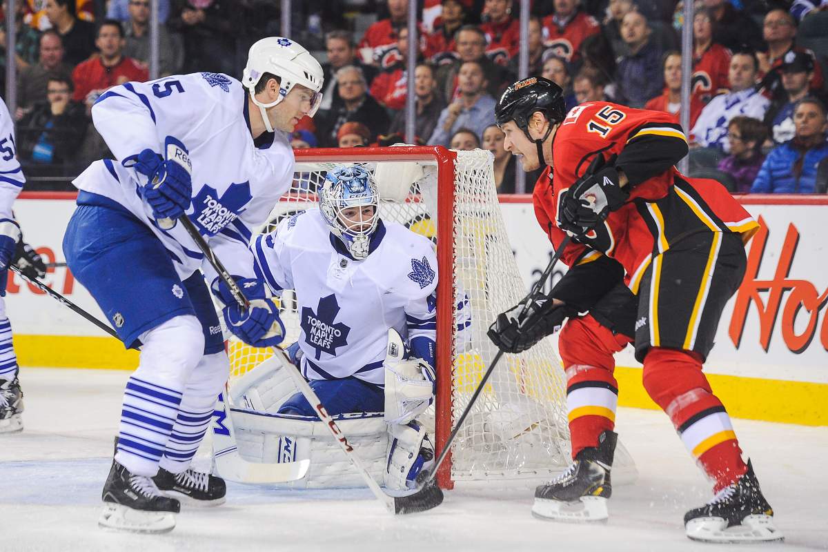  Jonathan Bernier #45 of the Toronto Maple Leafs defends the net against Tim Jackman #15 of the Calgary Flames during an NHL game at Scotiabank Saddledome on October 30, 2013 in Calgary, Alberta, Canada. 